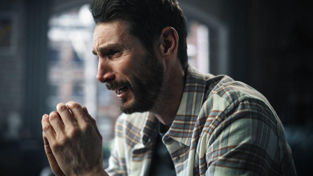 An emotional man, crying while suffering from what could be dual diagnosis - substance abuse and mental illness disorders.