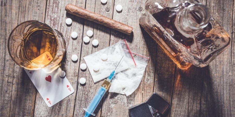 Addiction items on the table, alcohol, drugs, cigars and pills