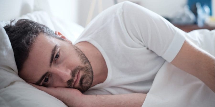 Man laying down on the bed feeling depression