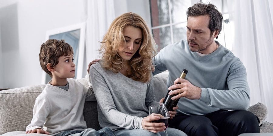 woman drinking alcohol near family child