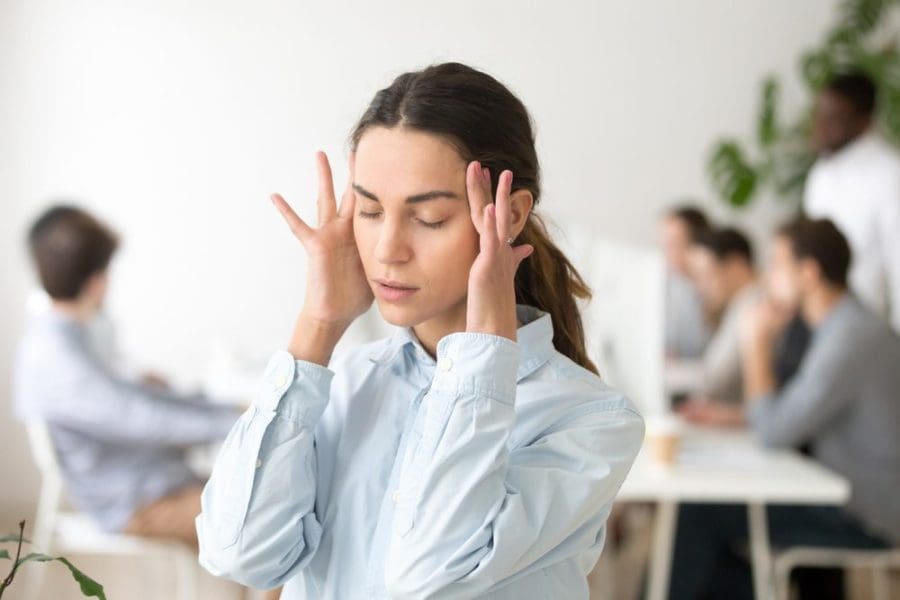 woman holding her head having a mental health - triggers